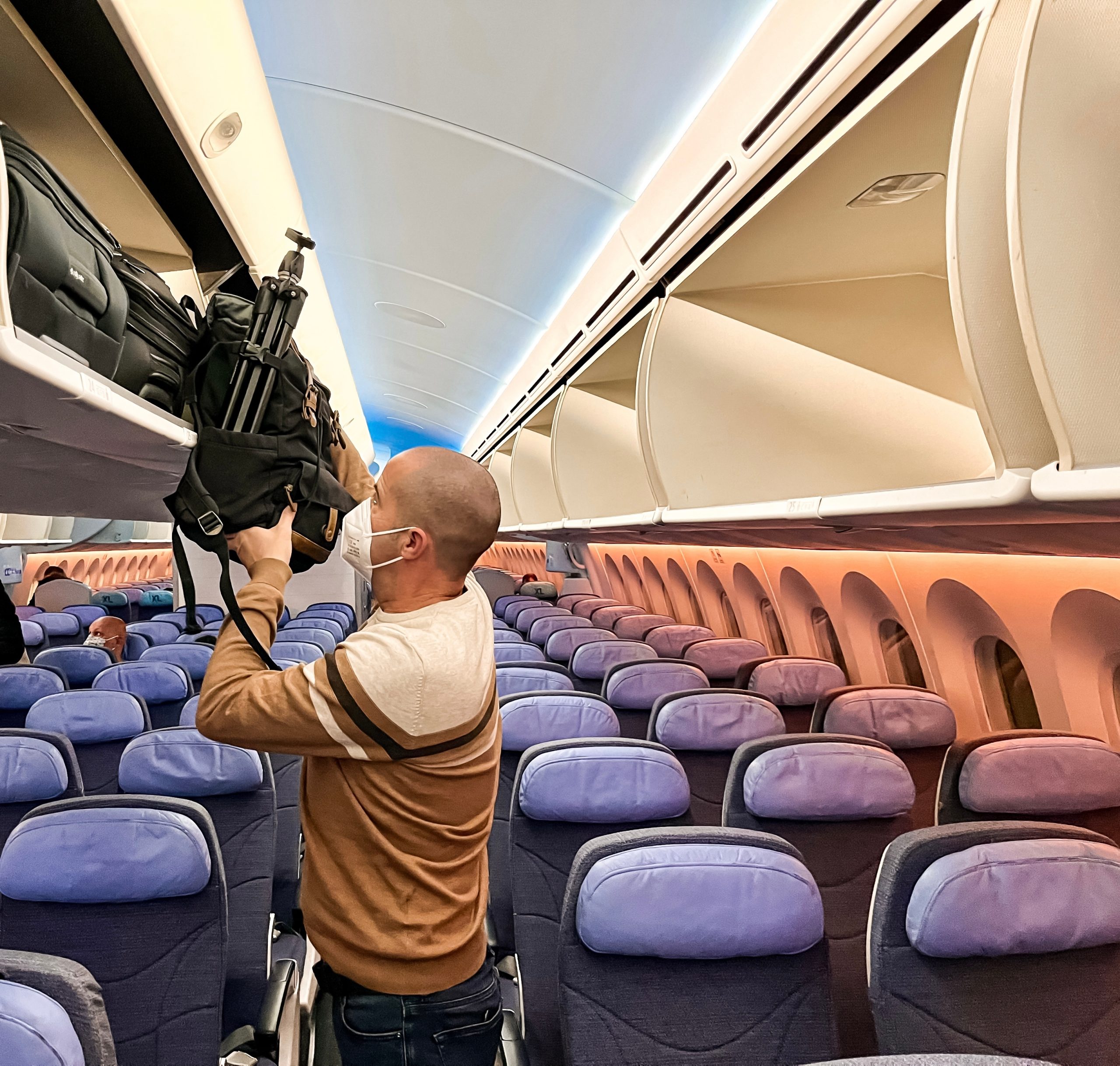 man-with-ffp2-face-mask-traveling-by-plane-puttin-2023-11-27-05-17-14-utc